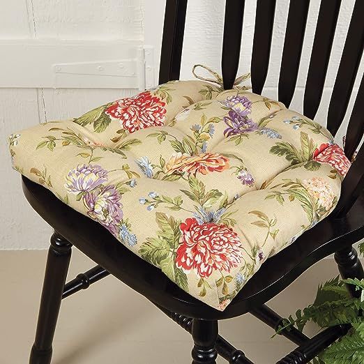 a chair with a flowered seat cushion on it next to a potted plant