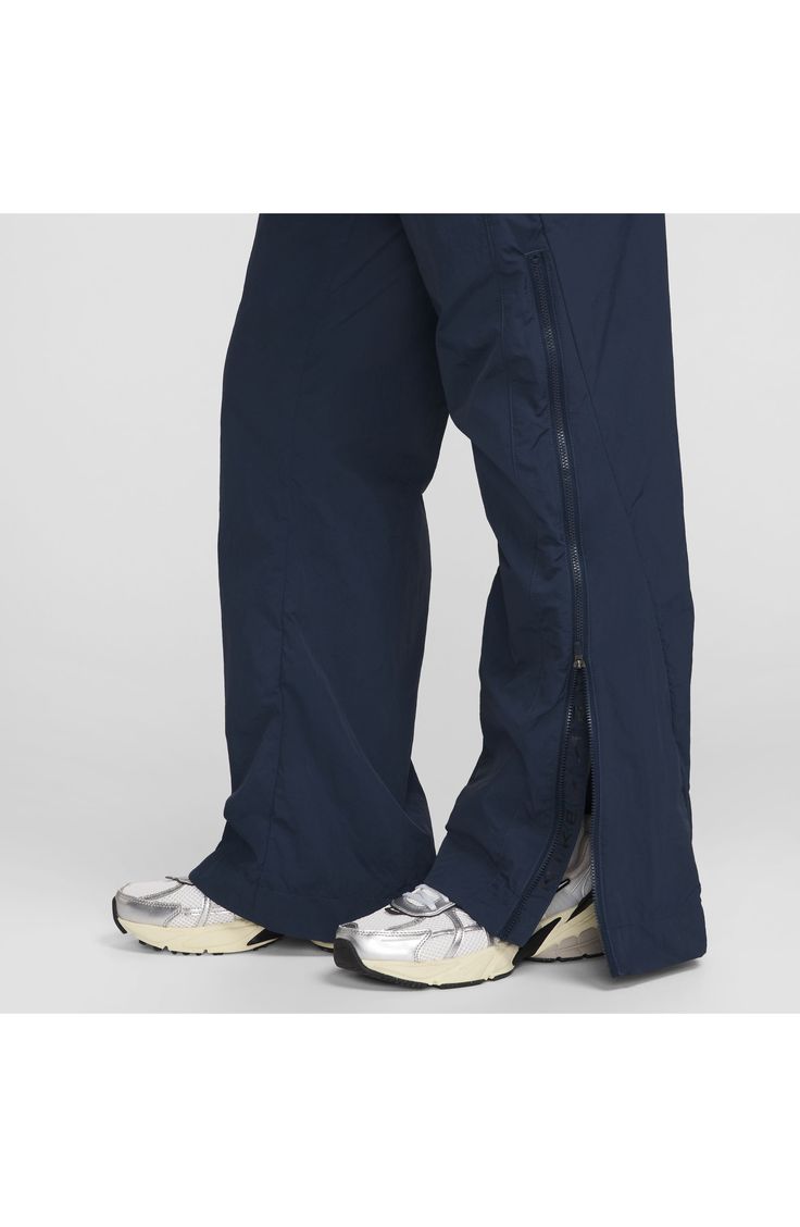 A water-repellent finish works with a sweat-wicking mesh lining on these sporty nylon drawstring pants finished with zippered hems for easy on and off. Elastic/drawstring waist On-seam welt pockets; back welt pocket Mesh lining 100% recycled nylon Machine wash, line dry Imported Moisture-wicking Nylon Techwear Bottoms, Nylon Techwear Pants With Functional Drawstring, Nylon Techwear Bottoms For Sports, Waterproof Nylon Athleisure Bottoms, Nylon Parachute Pants With Functional Drawstring For Outdoor, Nike Nylon Workout Bottoms, Nylon Athleisure Pants With Functional Drawstring, Nylon Outdoor Pants With Zip Fly, Nylon Pants With Zip Fly For Outdoor