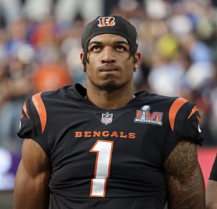 a close up of a football player wearing a black uniform with an orange number on it