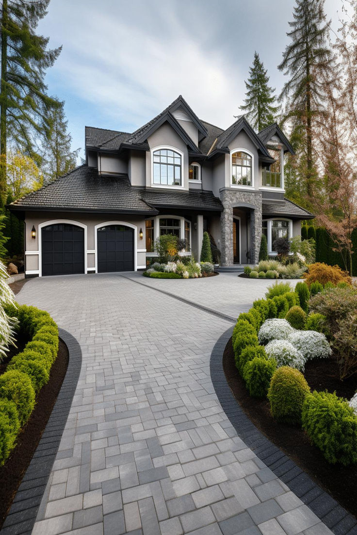 Elegant driveway landscaping with grey paving and lush greenery leading to a grand two-story home with dark roofing. Driveway Landscaping Ideas, Front Driveway Ideas, Front Garden Ideas Driveway, Beautiful Houses Exterior, Garden Ideas Driveway, Driveway Entrance Landscaping, Modern Driveway, Brick Driveway, Stone Driveway