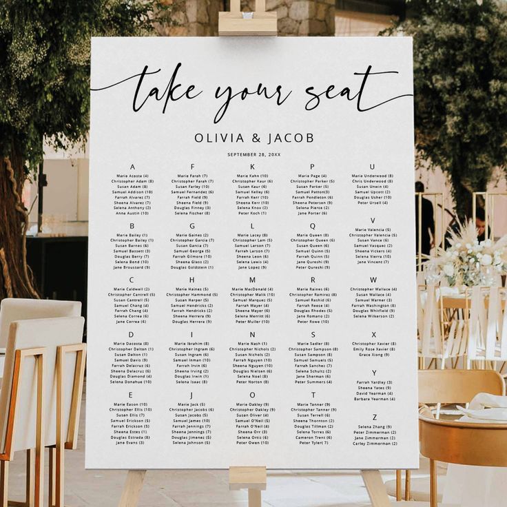 a seating chart for an outdoor wedding in front of a table with white chairs and greenery