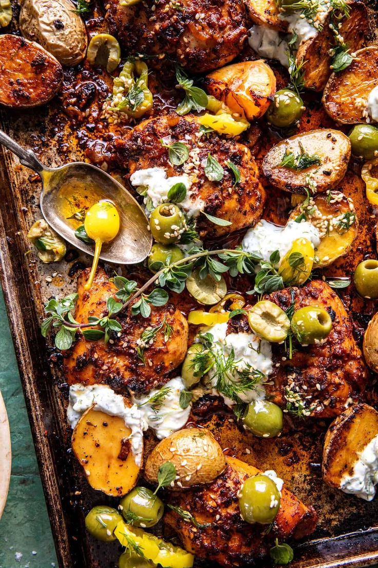 a tray filled with chicken, olives and potatoes