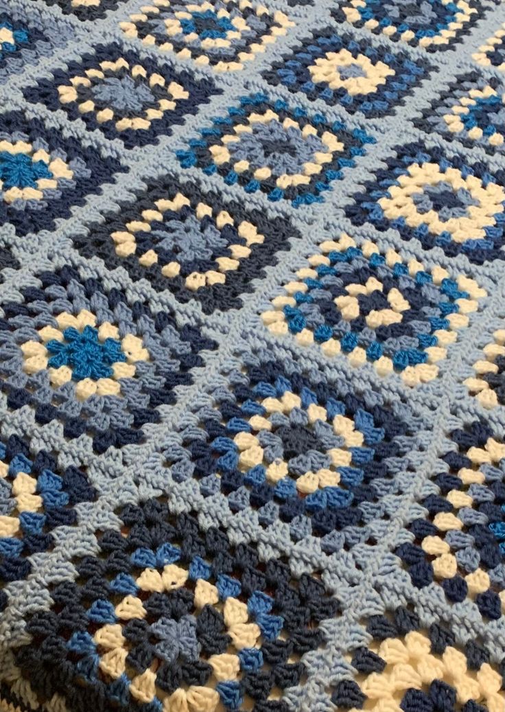 a blue and white crocheted rug on the floor