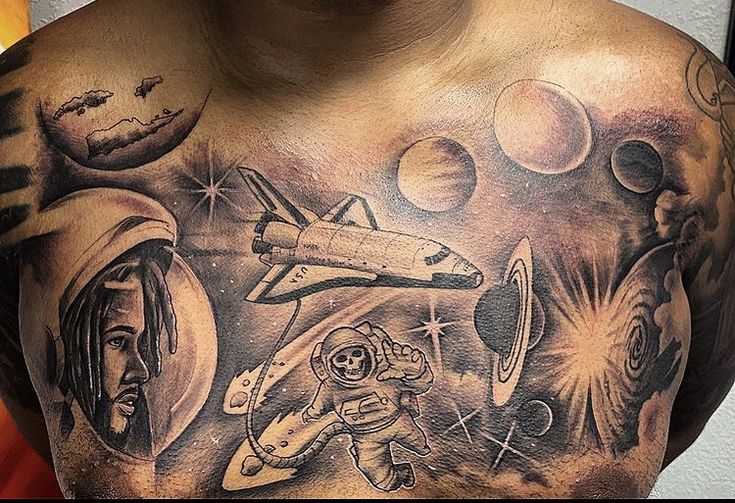 a man with tattoos on his chest has an image of the space shuttle and astronaut