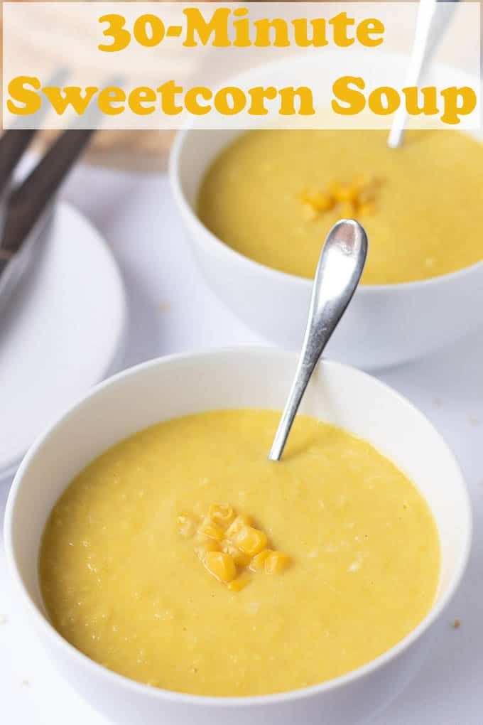 two white bowls filled with soup on top of a table next to silver spoons