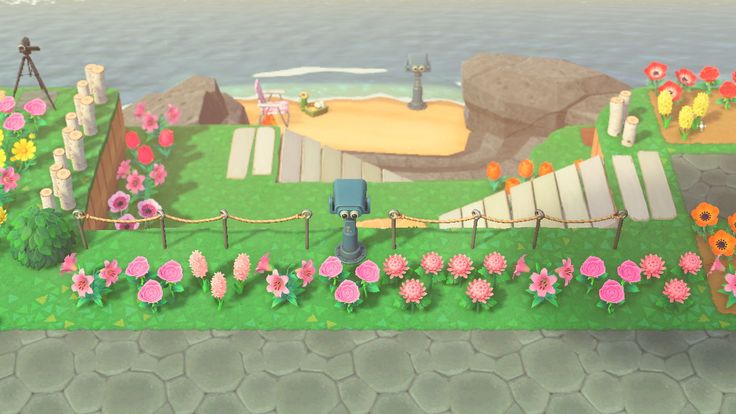 an animal crossing game with flowers in the foreground and a beach in the background