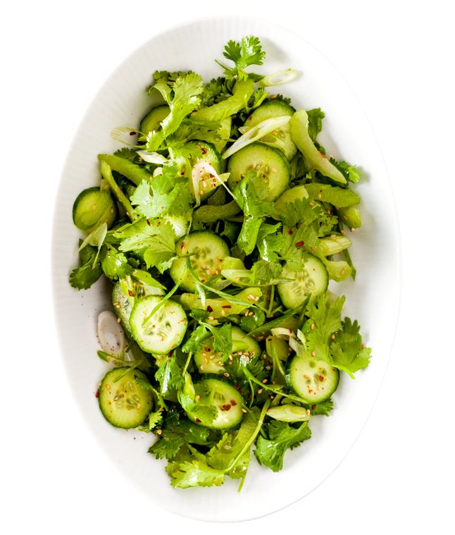 a white bowl filled with green vegetables on top of a table