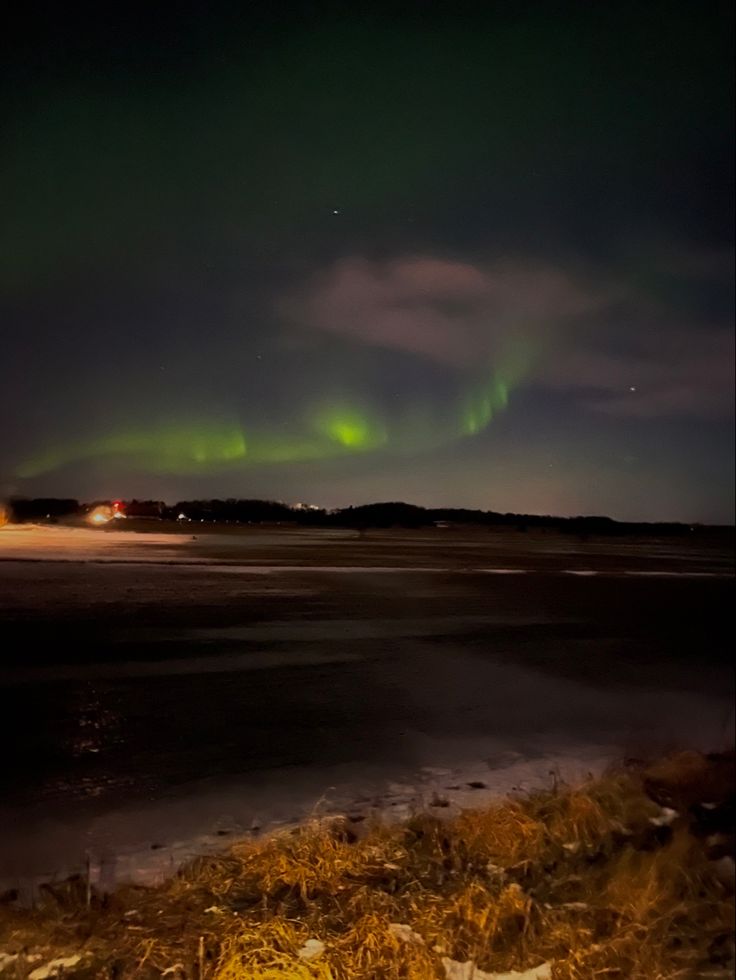 the northern lights shine brightly over an icy lake