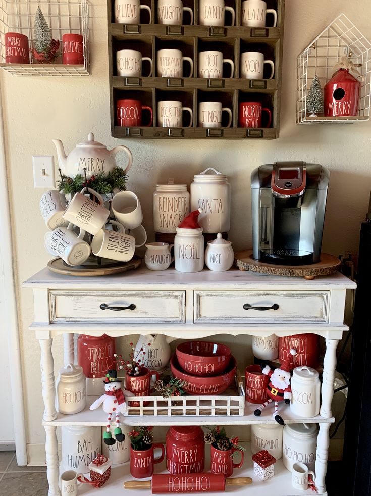 a white table topped with lots of red and white dishes next to a coffee maker