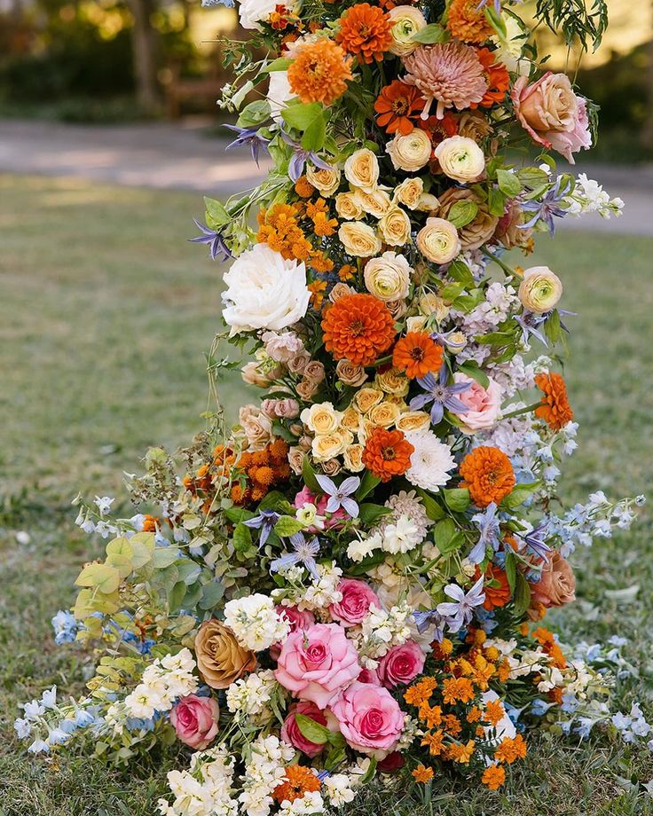 an arrangement of flowers is arranged on the ground