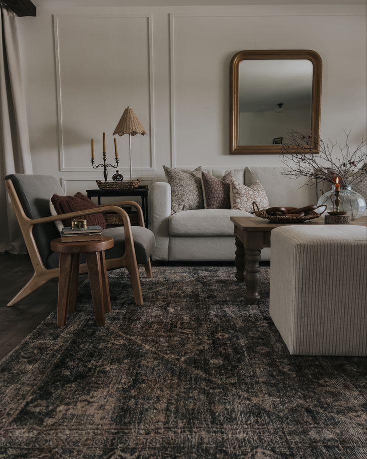 a living room filled with furniture and a mirror on the wall above it's headboard