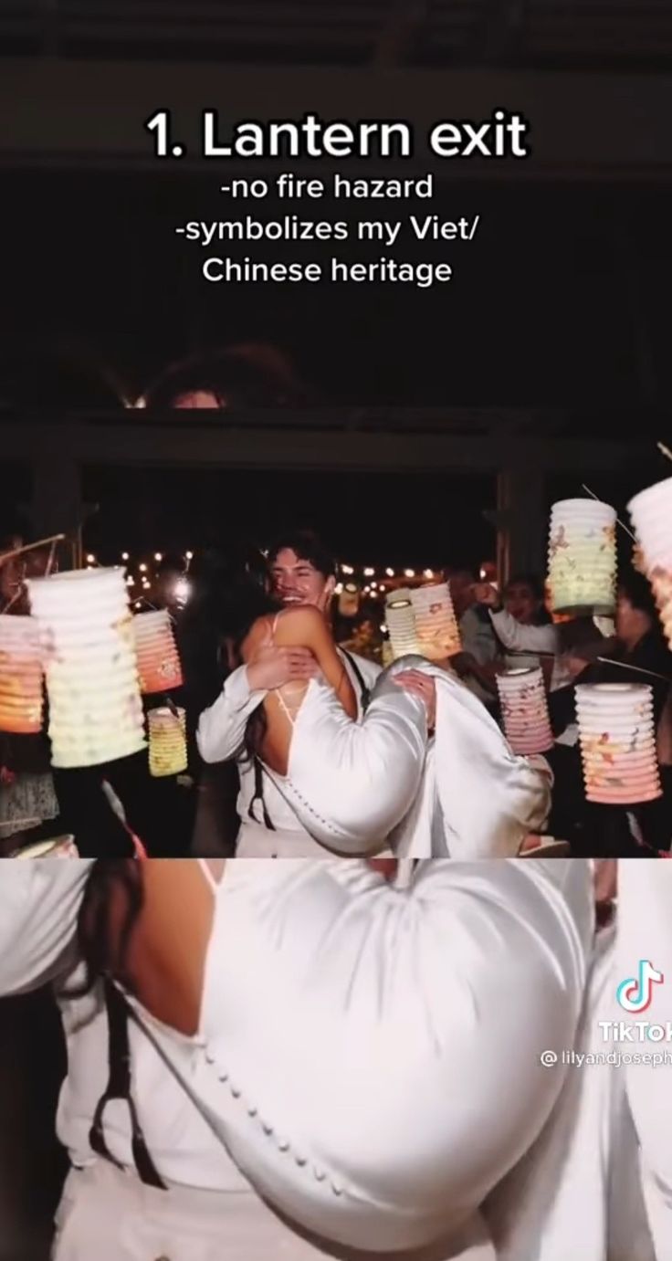 two people in white outfits are hugging each other and holding paper lanterns above their heads