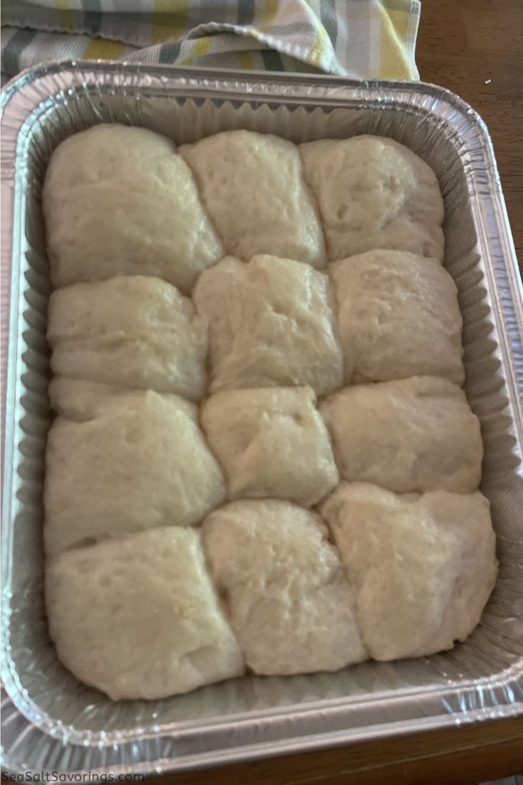 a pan filled with rolls sitting on top of a wooden table