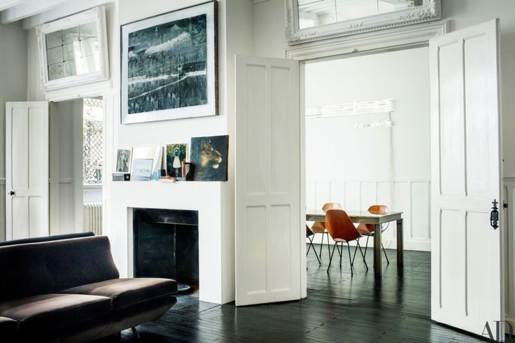 a living room filled with furniture and a fire place in front of a white fireplace