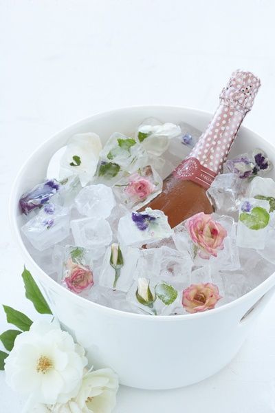 a white bowl filled with ice and flowers next to a pink toothbrush on top of it