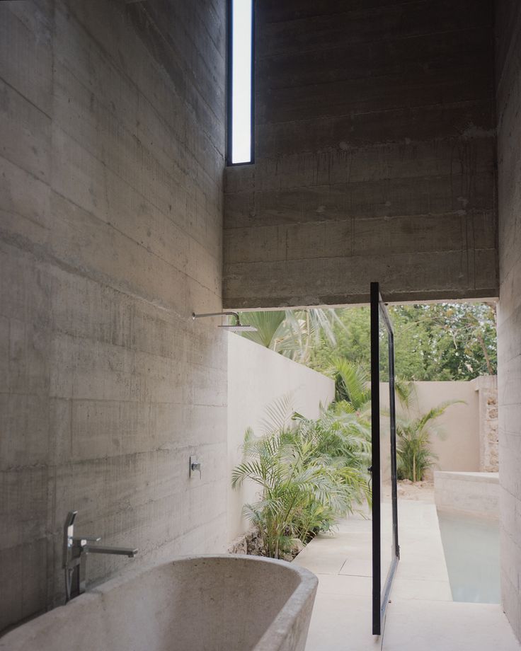 a bath tub sitting in the middle of a bathroom next to a wall with windows