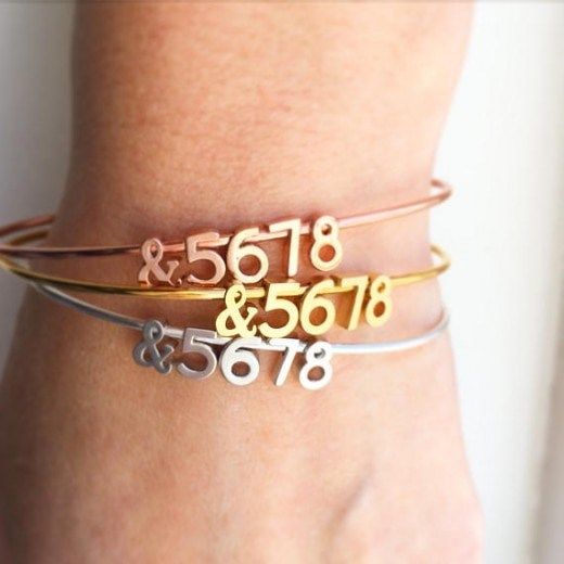 two different bracelets with numbers and date on the side, one for each woman's wrist