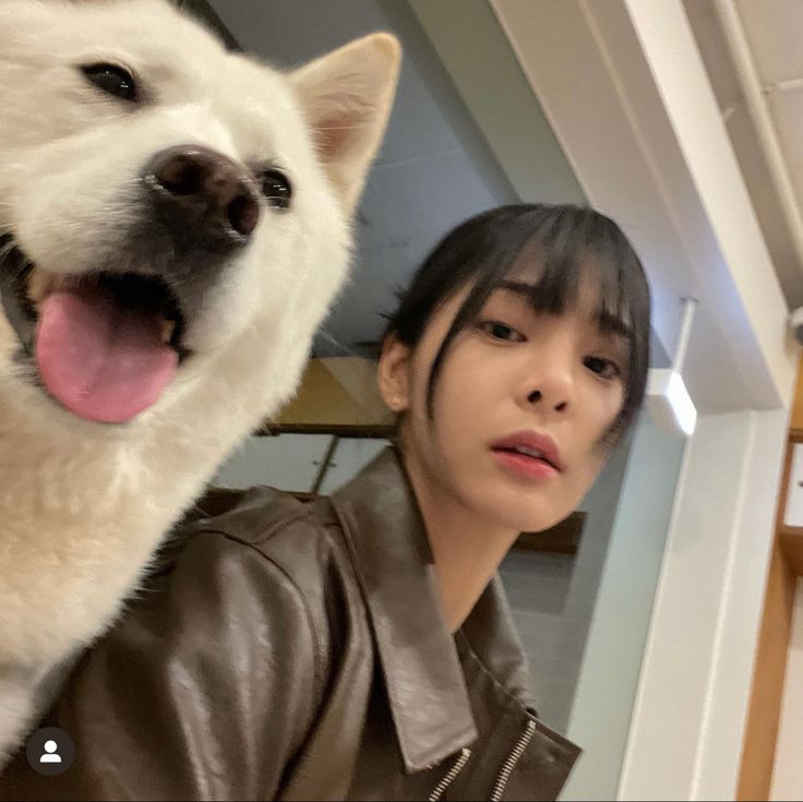 a woman standing next to a white dog