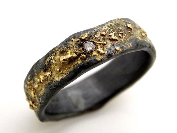 a close up of a ring with gold and diamonds on the inside, against a white background