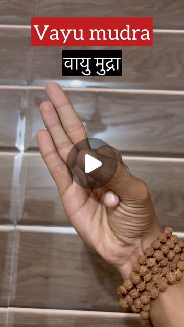 a person holding their hand up in front of a tile wall with the words varu mudra written on it