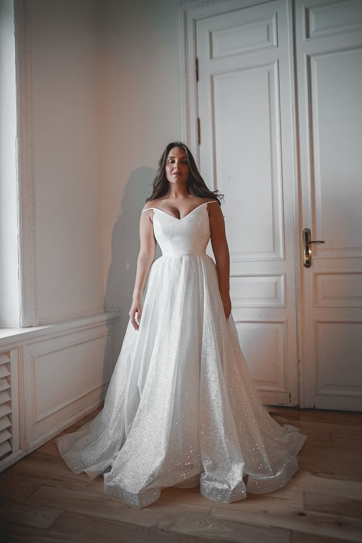 a woman in a wedding dress posing for the camera