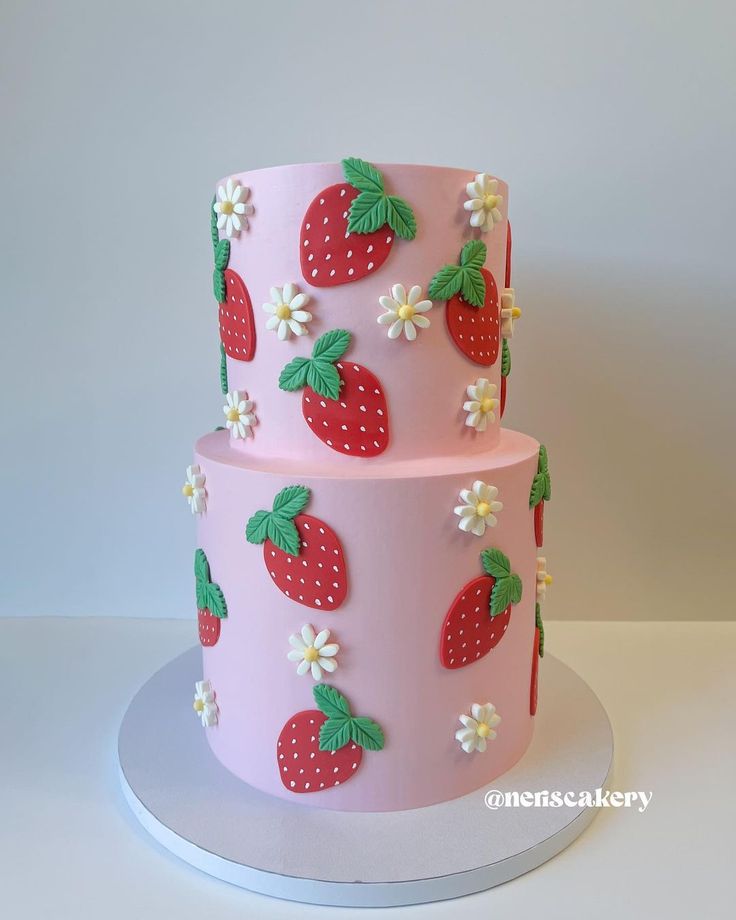 two tiered cake decorated with strawberries and daisies