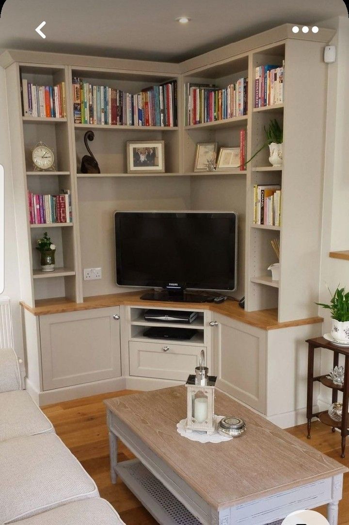 a living room filled with furniture and a flat screen tv on top of a wooden table