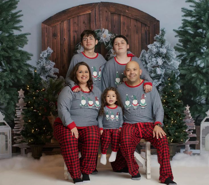 a family in matching christmas pajamas posing for a photo