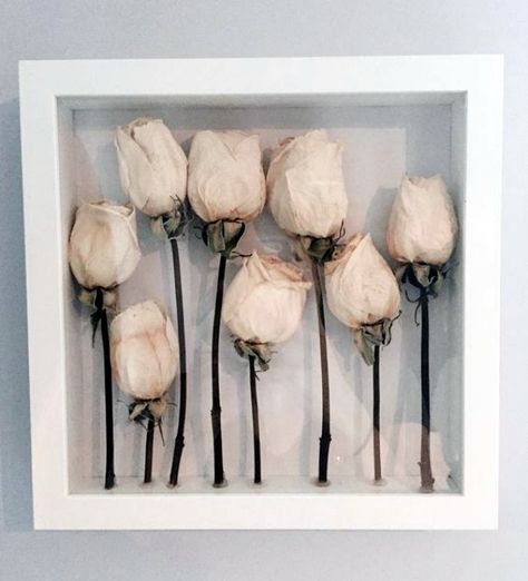 there is a white frame with flowers in it