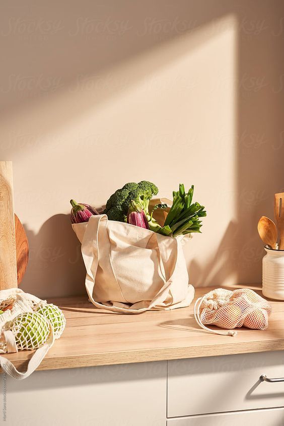 a bag full of vegetables sitting on top of a counter next to other kitchen utensils