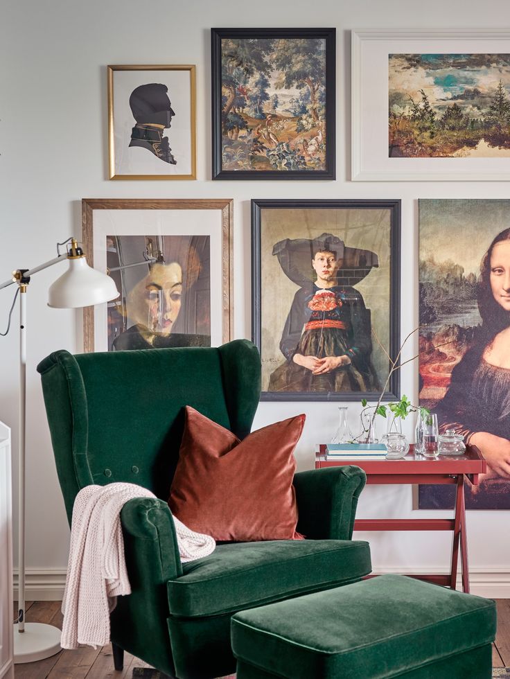 a green chair and ottoman in front of pictures on the wall