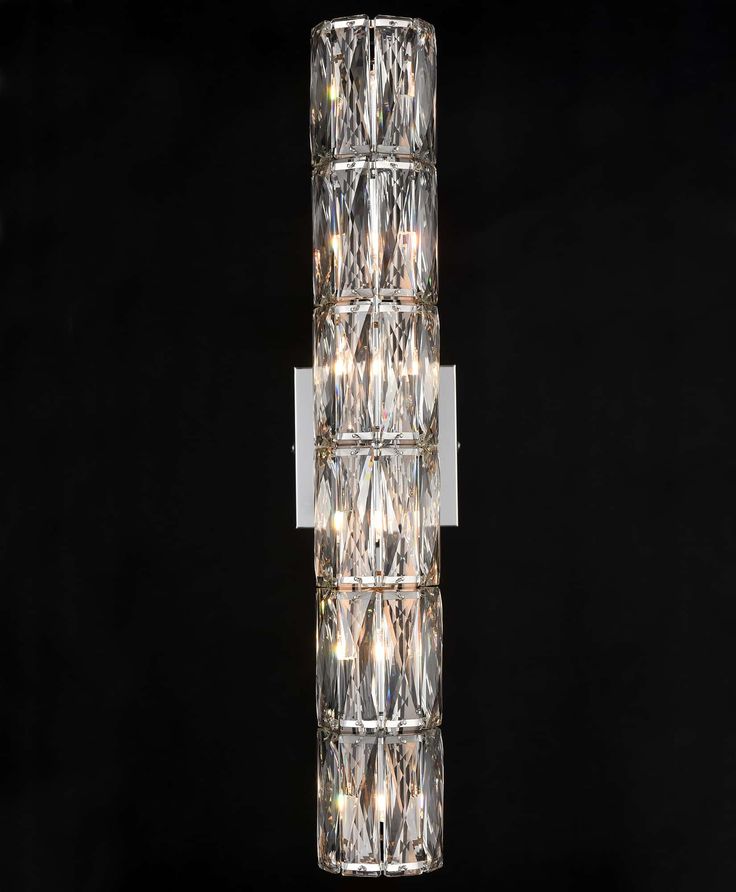 a large glass light fixture on a black background with lights in the corner and behind it