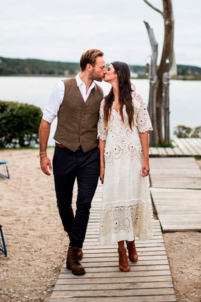 a man and woman walking down a wooden walkway