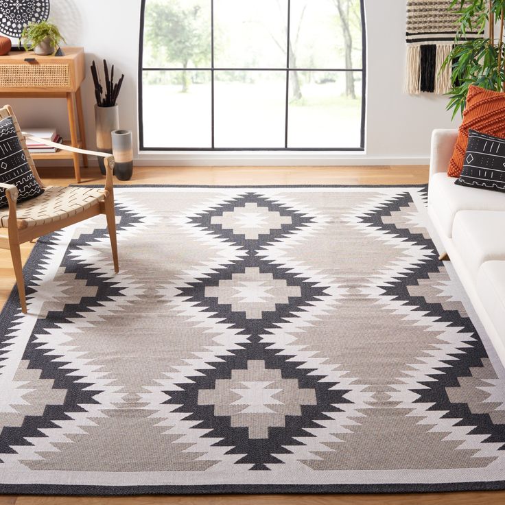 a living room with a white couch and black and white rug on top of it