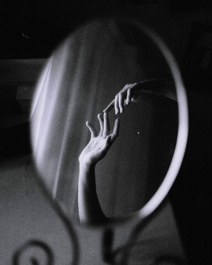 a person's hand is seen through a magnifying glass in this black and white photo