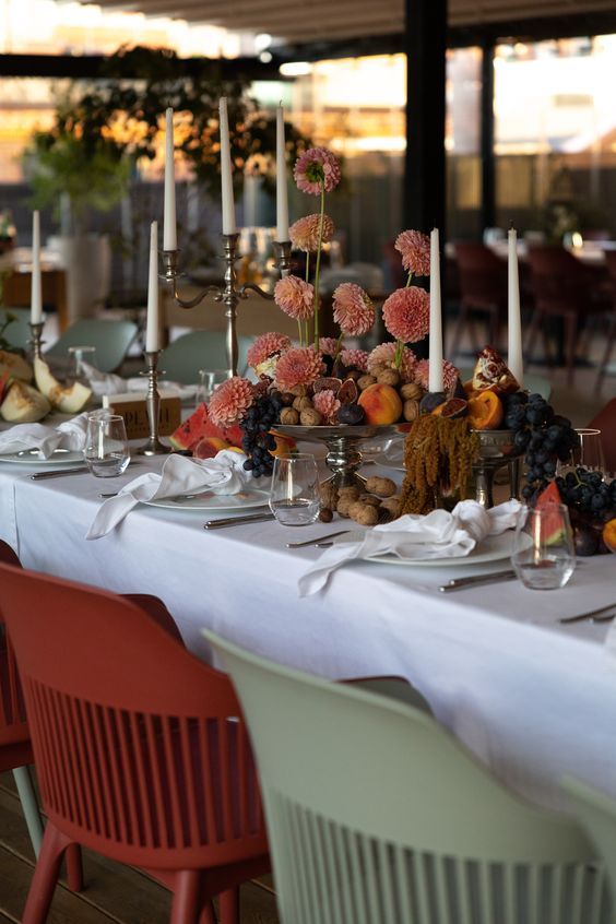 a long table is set with plates and candles