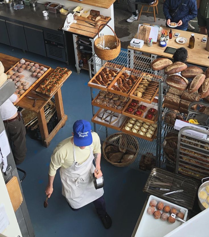 an overhead view of people working in a bakery with lots of breads and pastries