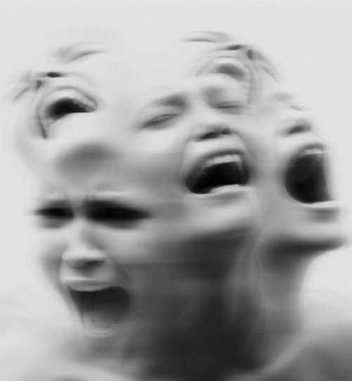 an alien woman with her eyes open and mouth wide open in front of the camera