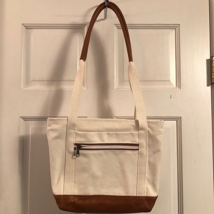 Beige Canvas Shoulder Mini-Tote Bag With Brown Leather Trim Bottom And Shoulder Straps. 2 Outside Pockets- 1 Zippered, 1 Inside Picket. Zippered Top Closure. Measurements: 12”W X 10”H X 3.5”D X 14” Drop. Brand New. Never Worn. No Tags. Cream Canvas Bucket Shoulder Bag, Cream Canvas Bucket Bag With Adjustable Strap, White Shopping Bag With Canvas Lining, Cream Canvas Bucket Bag For Travel, Casual Cream Leather Bag, White Bucket Bag With Canvas Lining, White Bucket Shoulder Bag With Canvas Lining, Cream Canvas Shoulder Bag With Double Handle, White Shoulder Bag With Canvas Lining For Shopping