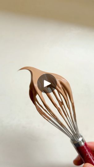 a hand holding a whisk with an image of a bird on it's side