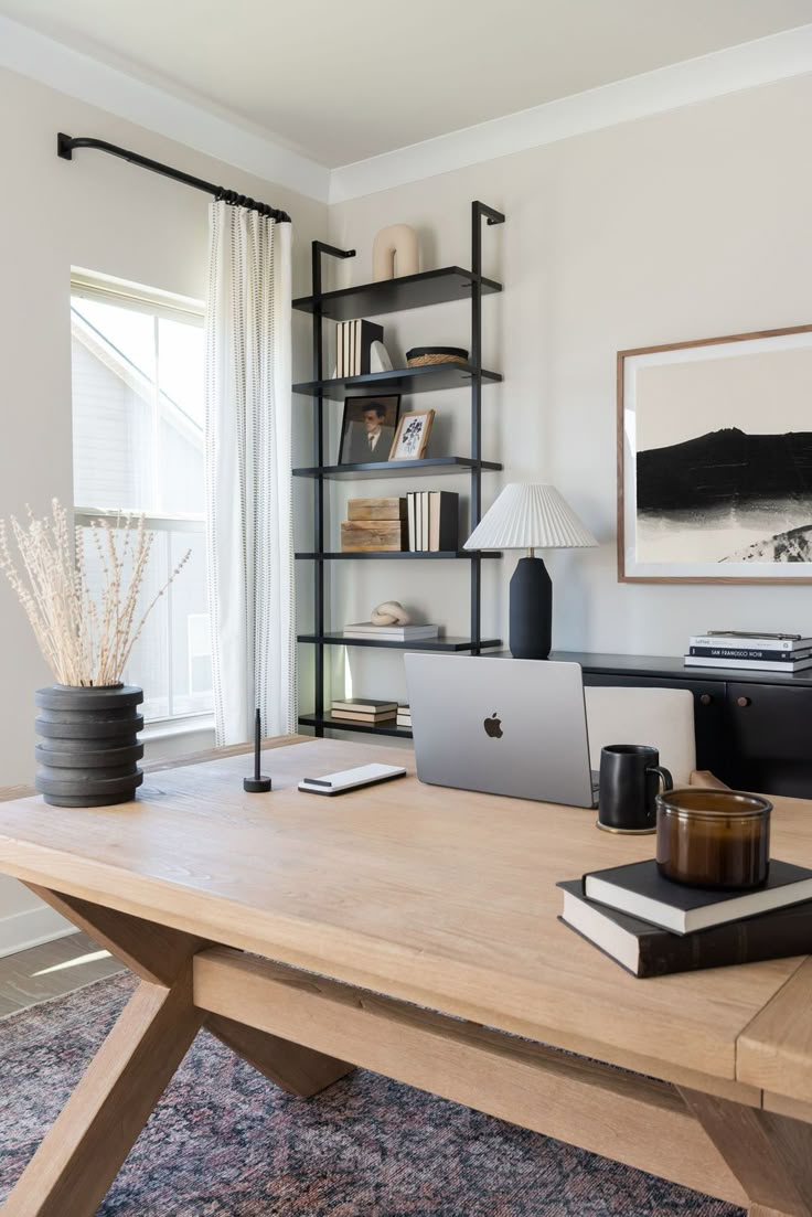 a desk with a laptop computer on top of it next to a lamp and bookshelf