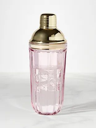 a pink glass shaker sitting on top of a white counter next to a silver lid