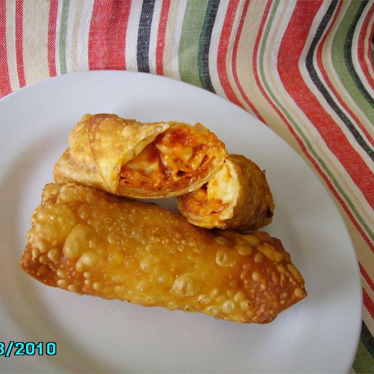 two pastries on a white plate sitting on a striped table cloth