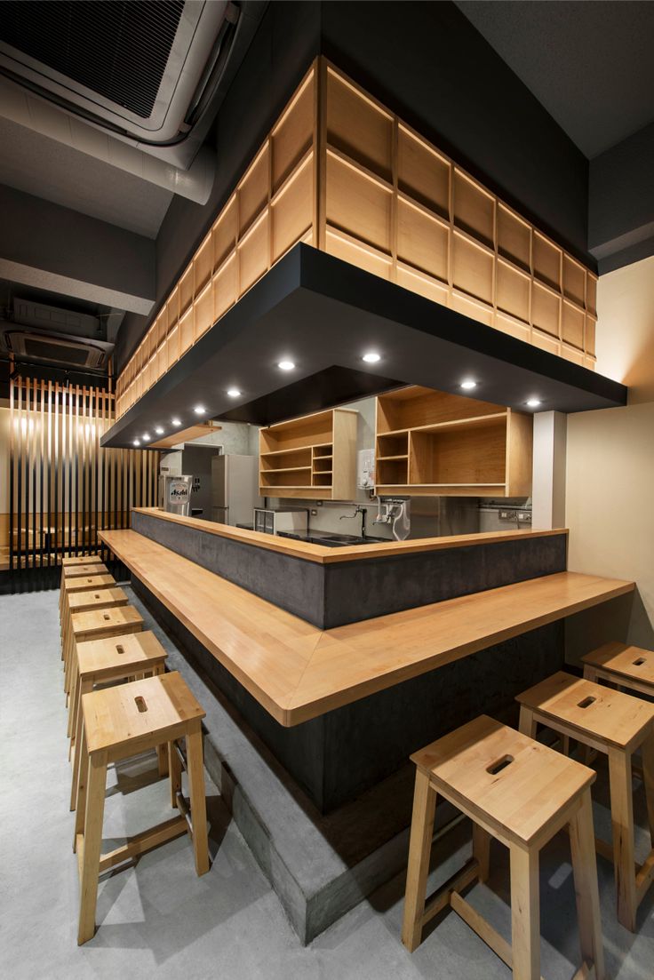 an image of a restaurant with wooden tables and stools in the middle of it