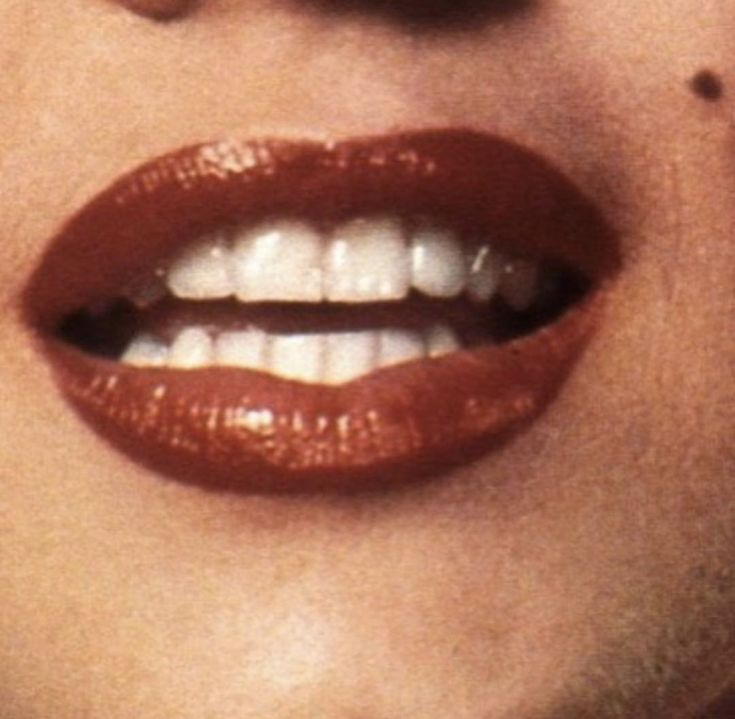 a close up of a woman's lips with white teeth