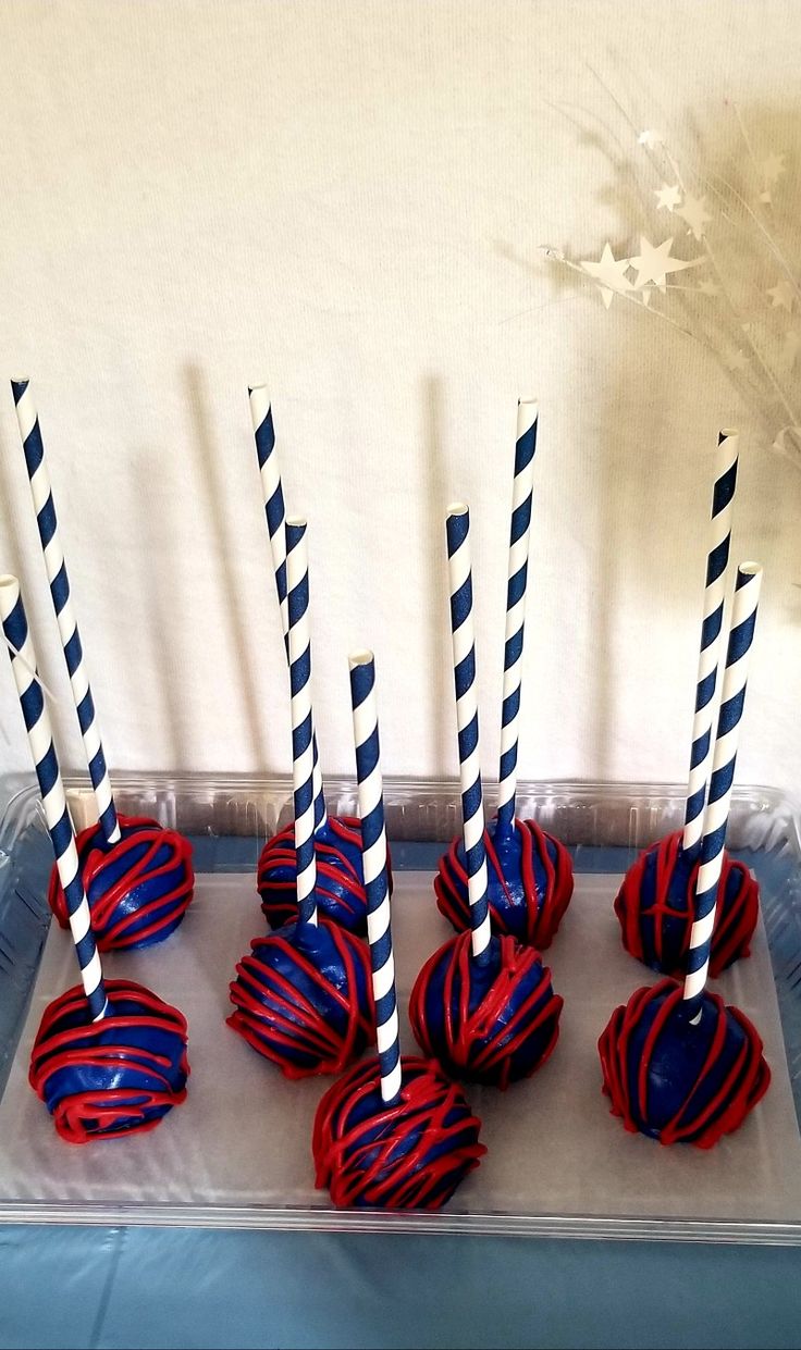 six red, white and blue striped candy lollipops on a tray