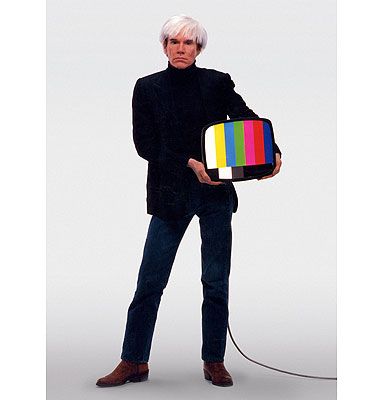 the man is holding a television with a multicolored tv on it's back