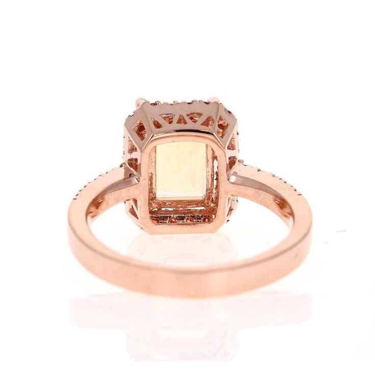 This gorgeous ring has a beautiful Emerald Cut Citrine Quartz weighing 2.23 Carats and is surrounded by a Halo of 22 Round Cut Orange Sapphires weighing 0.50 Carats. Along the shank of the ring are 10 Round Cut Diamonds that weigh 0.18 Carats (Clarity: SI2, Color: F). The total Carat weight is 3.35 Carats.  It is set in 14K Rose Gold and weighs approximately 4.9 grams. This ring is a size 7  Exact dimensions for this item are unknown. Please reach out in the seller Q&A for any questions on measu Elegant Citrine Diamond Ring With Halo Setting, Elegant Citrine Topaz Ring With Halo Setting, Formal Citrine Cushion Cut Ring, Formal Cushion Cut Citrine Ring, Yellow Halo Rings Fine Jewelry, Citrine Cushion Cut Jewelry For Anniversary, Cushion Cut Citrine Gemstone Rings, Classic Citrine Jewelry With Halo Setting, Yellow Citrine Ring With Halo Setting