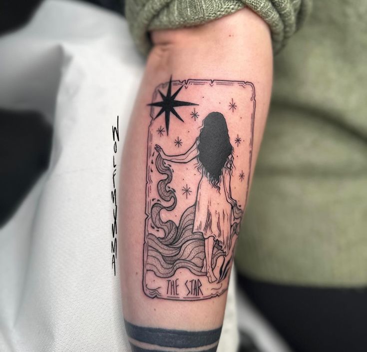 a woman's arm with a tarot card tattoo design on the left upper arm