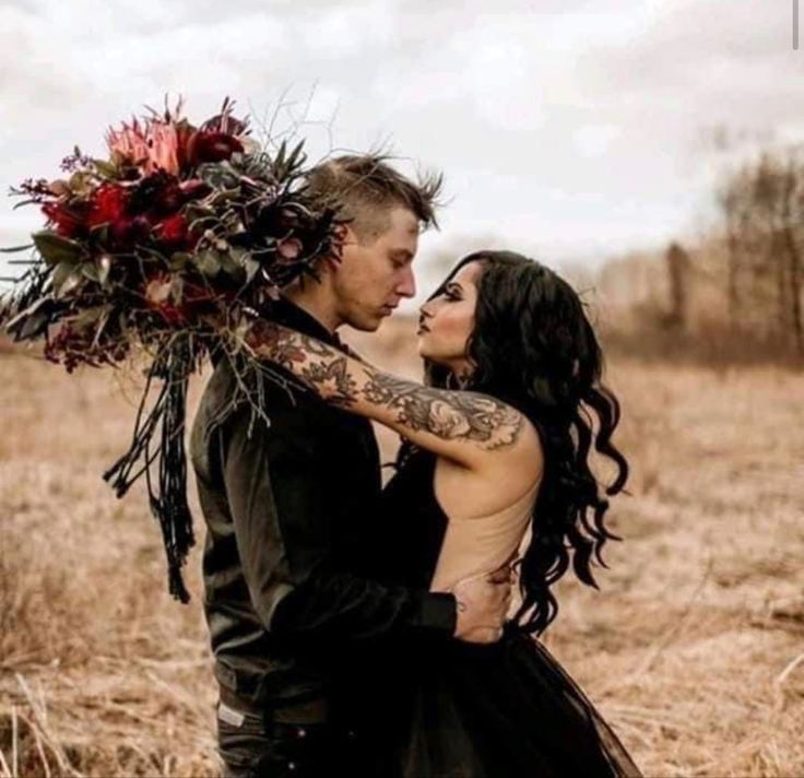 a man and woman standing in a field with flowers on their foreheads, holding each other